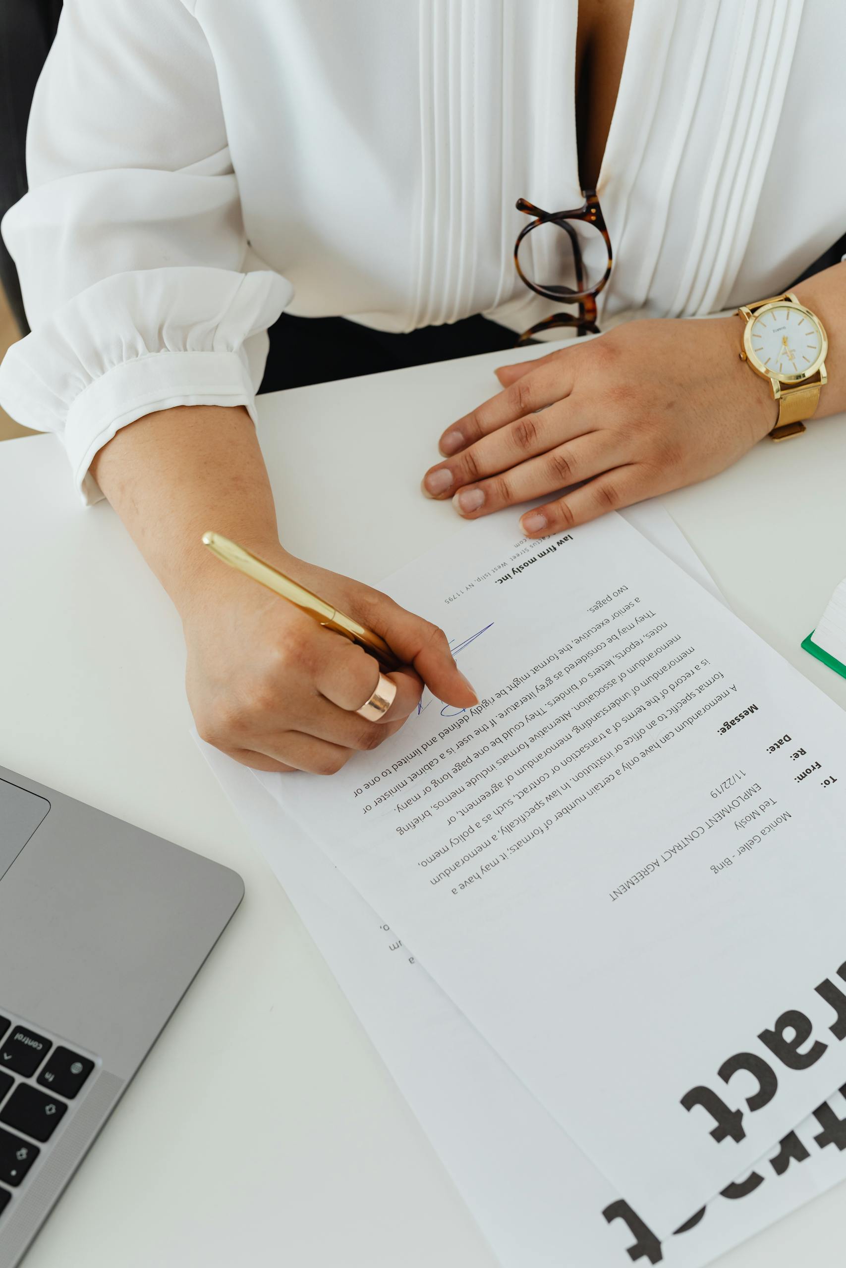 A focused businesswoman signing a contract in a modern office environment.